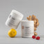 Two containers of 'aggie' brand product with a lemon, ginger root, and raspberries on a gray background. Morning Relief support pregnancy sickness, morning sickness, hyperemesis gravidarum nausea and vomiting during pregnancy.